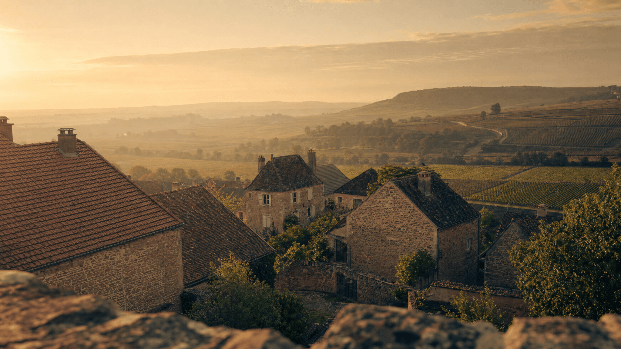 Village bourguignon au lever du jour, vallée viticole, contexte de rénovation énergétique rurale française